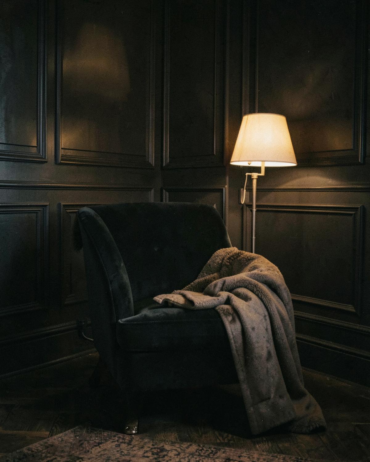 Portrait placeholder. A quiet, lamp-lit London interior